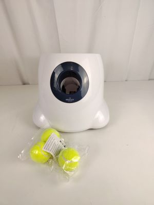deux balles de tennis dans un sac en plastique, à côté d'un distributeur de balles de tennis