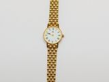 une montre-bracelet en or avec un cadran blanc et un bracelet en or