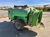 un gros tracteur vert avec une grande roue sur la route