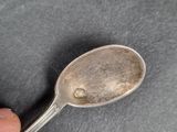 a silver spoon with a hole in the middle of it