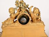 a gold clock with cherensils and cherensils on it