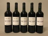 quatre bouteilles de vin rouge sont alignées