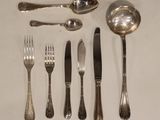 a lot of silverware on a table with spoons and forks