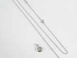 a close up of a necklace and a chain on a white surface
