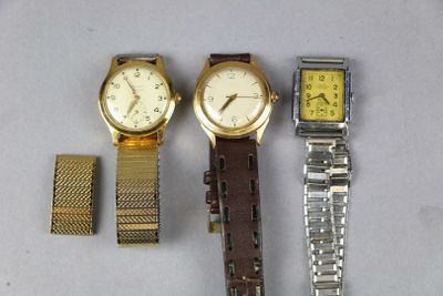 trois montres différentes sont posées les unes à côté des autres sur une table
