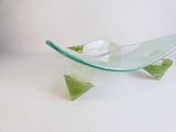 a glass bowl with a green leaf on top of it