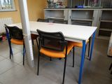 tables and chairs in a room with a white table and orange chairs