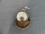 a small pocket with a clock on it on a table