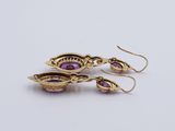 a pair of gold earrings with amethtites and amethtites