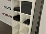 a white bookcase with a television on top of it
