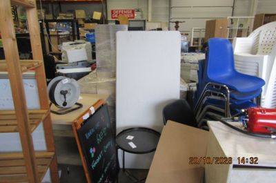 un réfrigérateur au milieu d'une pièce où se trouve une pile de cartons