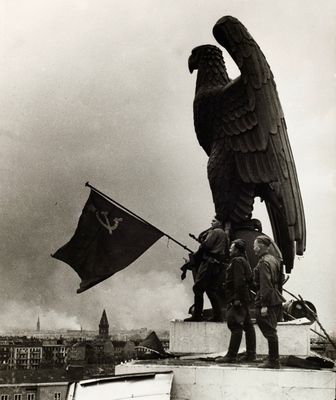 photo en noir et blanc d'une statue d'aigle au sommet d'un immeuble