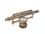 un télescope ancien en laiton, avec un cadran blanc sur fond blanc