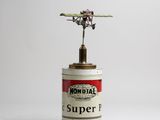 an old tin can with a small airplane on top of it