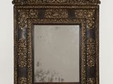 an ornate mirror with a wooden frame on a white wall