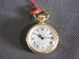 a gold pocket watch with roman numerals on it