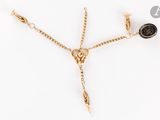 un gros plan d'un collier en or orné d'une pierre noire