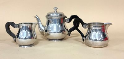 un service à thé et à café en argent composé de trois pièces, posé sur une table
