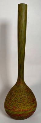 un vase vert posé sur une surface blanche