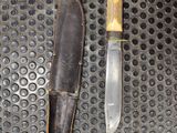 a knife and a knife sheath on a metal surface