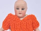 a doll that is wearing a knitted orange dress