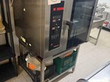 a silver microwave sitting on a metal shelf in a kitchen