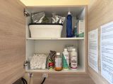 a bathroom cabinet with a lot of items in it