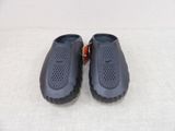 pair of black slippers with holes on them on a white surface