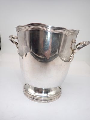 a large silver bowl with handles on a table