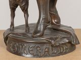 a bronze statue of a woman and a dog on a table