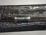 portefeuille en cuir de crocodile avec un fermoir métallique sur fond blanc