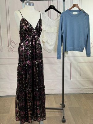 une robe posée sur un mannequin à côté d'un pull suspendu à un cintre