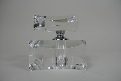 un flacon de parfum en verre transparent muni d'un bouchon argenté
