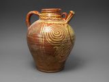 un vieux vase marron orné d'un motif en spirale