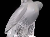 a glass sculpture of an eagle on a black background