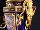a blue and gold vase with a statue on it