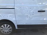 a white van that has been vandalized and is parked in a parking lot