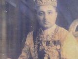 an old photo of a man wearing a crown and holding a sword