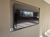 a man standing in front of a large mirror in a room