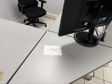 un bureau avec un écran et une chaise dans la pièce