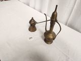 pair of antique brass teapots on a table with a white table cloth