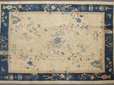 an antique chinese rug with a blue border and floral design