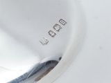 a close up of a silver object on a white surface