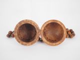 a pair of wooden bowls sitting on top of a white surface