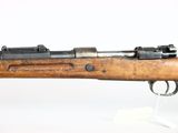 a close up of a rifle on display on a white surface