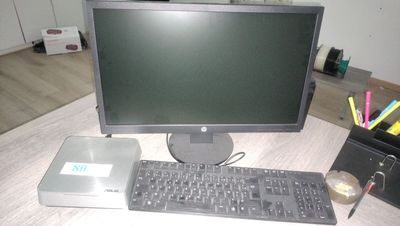 un ordinateur de bureau posé sur une table à côté d'un clavier et d'une souris