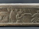 an old wooden box with carvings on it sitting on a table