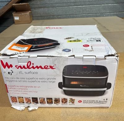 emballage d'un micro-ondes posé sur une boîte en carton, sur une table