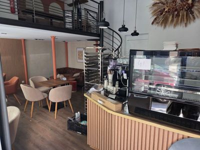 un café avec un escalier menant au deuxième étage