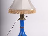 une image représentant une lampe bleue surmontée d'un abat-jour blanc